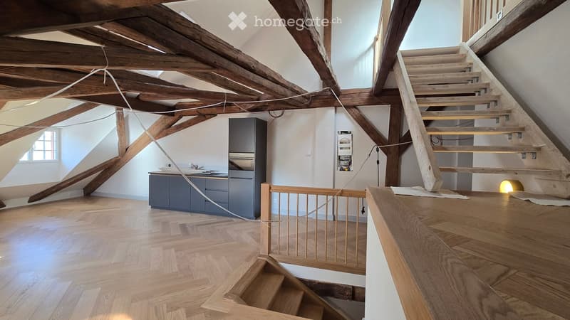 wooden floor, wooden beams, kitchen area with oven, cabinets, sink, staircase