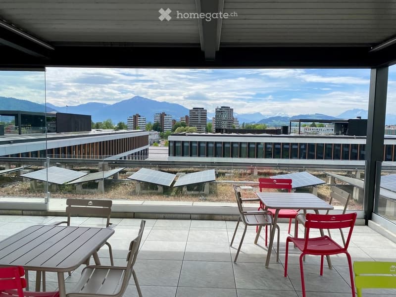 Modern rooftop terrace with outdoor furniture, solar panels, and a scenic mountain view.