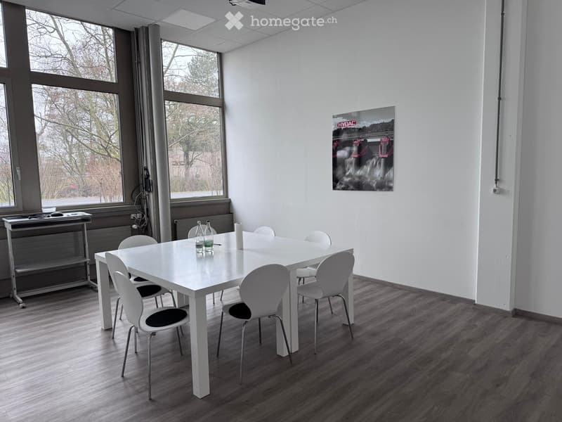 white desk with chairs, picture frame on wall, table with bottles, desk with wheels, wooden floor