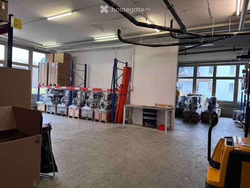 Warehouse room, metal shelves, large cardboard boxes, clear floor, forklift, large windows