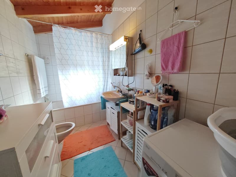 Bathroom with bathtub, sink, toilet, and washing machine.