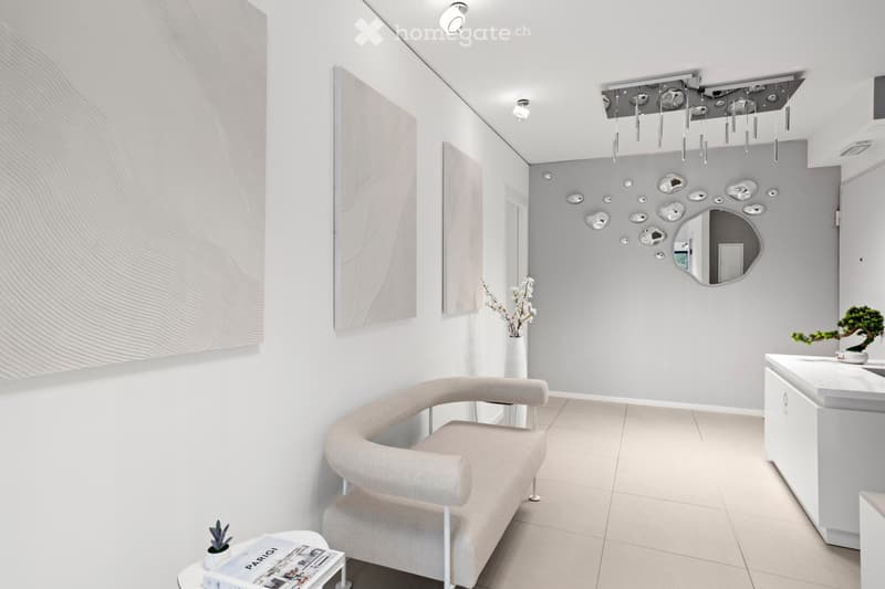 White walls, beige sofa, modern art pieces, floating ceiling lights, potted plants, and a mirror.