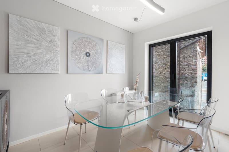 modern dining room with glass table, clear chairs, wall art, large windows