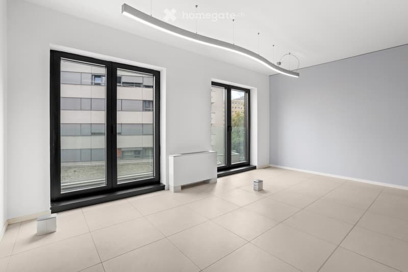 Empty room with beige tiles, white walls, 2 large windows with balcony, modern lighting, and a radiator