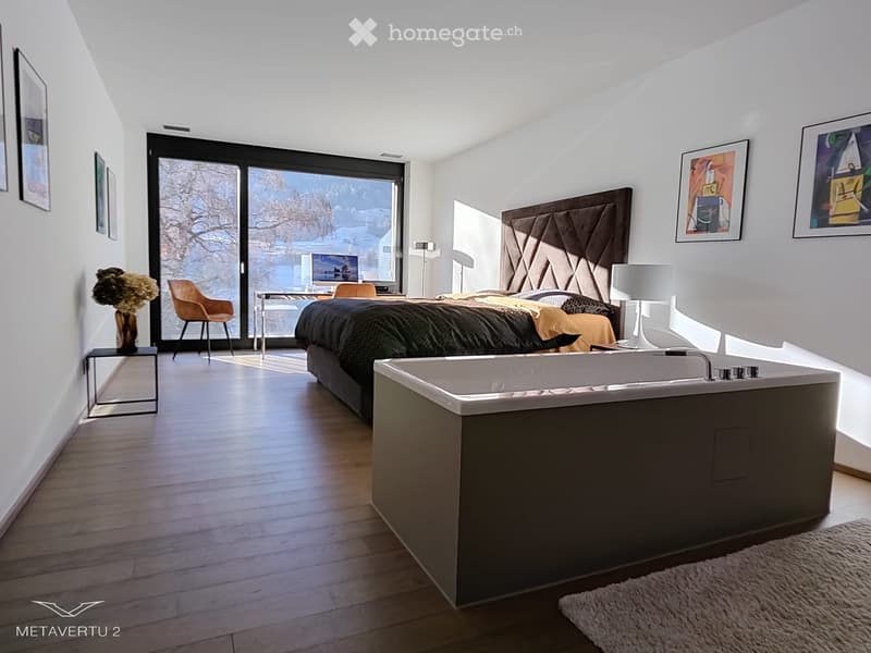 modern interior design, white walls, hardwood floors, large bed, desk with computer, tub, artwork