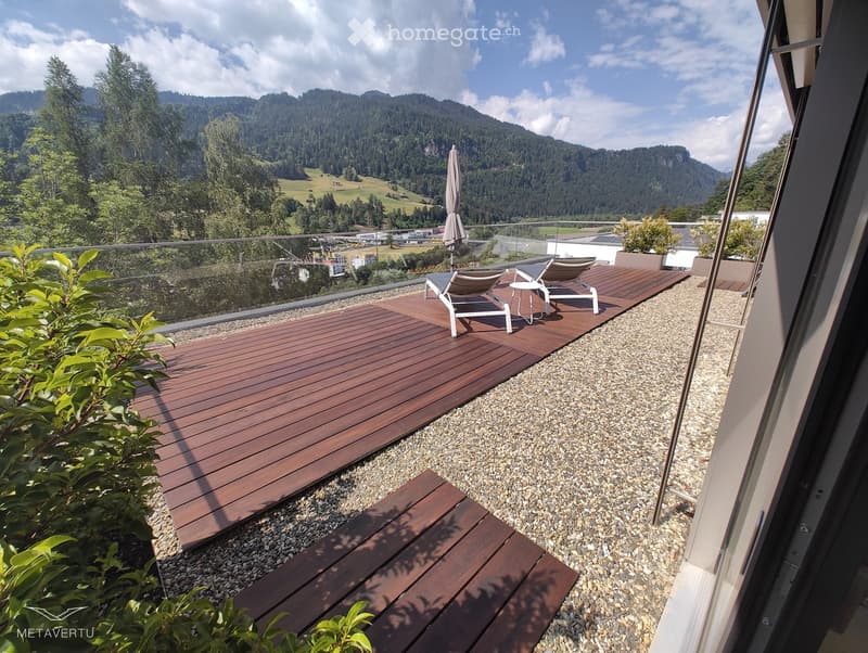 wooden deck, gravel path, lounge chairs, umbrella, potted plants, fenced railing, view of mountains