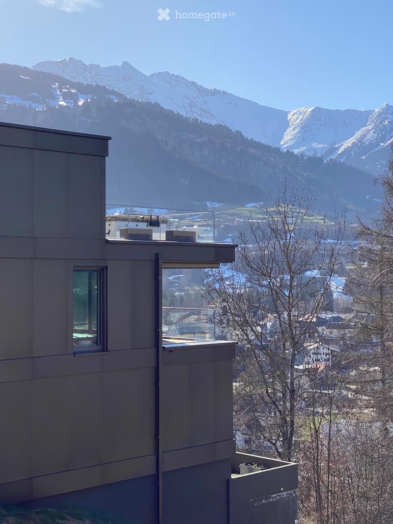 building with glass window and glass balcony, view of mountain in the distance