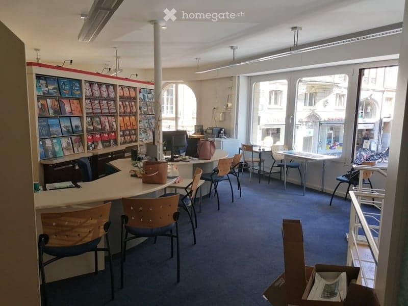 Office with bookshelves, chairs, desk, computer, windows, carpeted floor