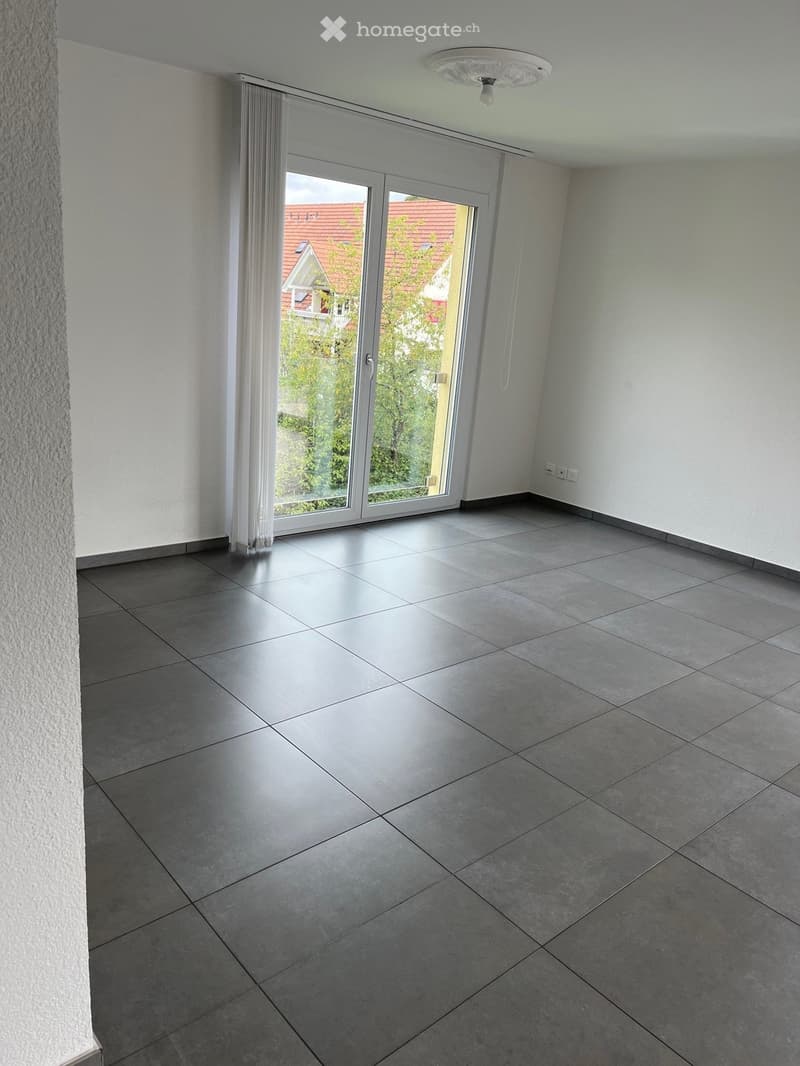 empty room, sliding glass door, white walls, gray floor tiles, window curtains, electrical outlet