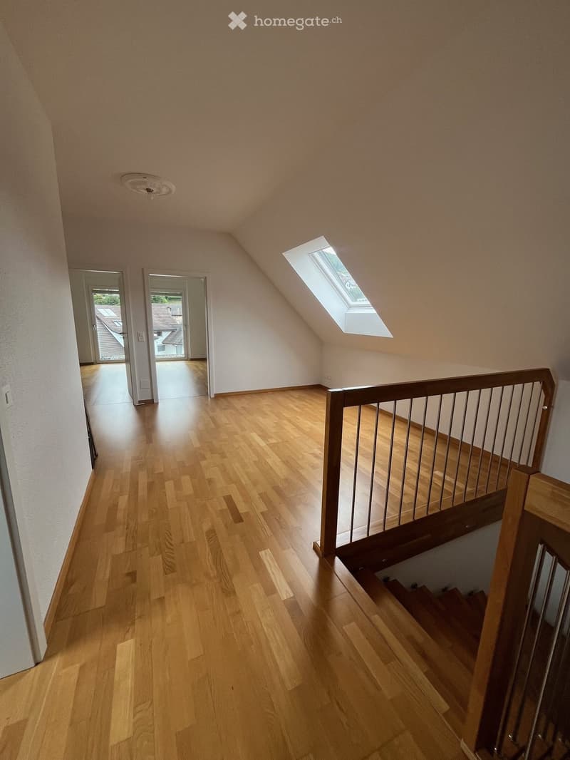 Wooden floor, staircase, white walls, skylight window, wooden handrail