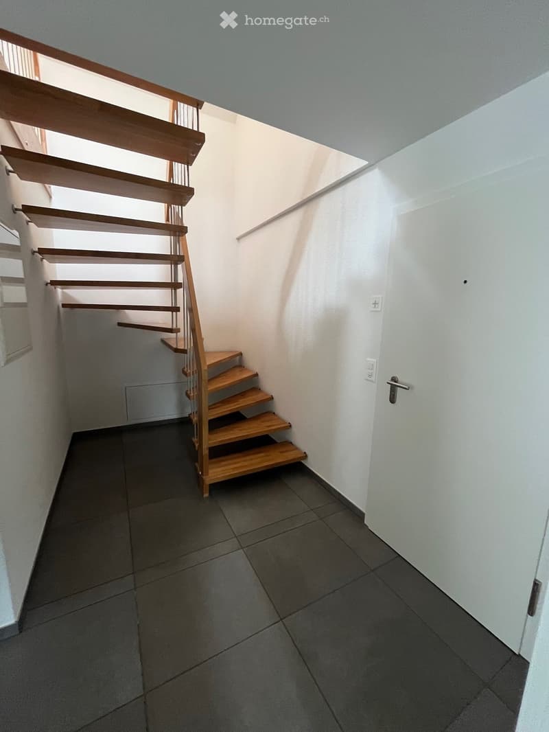 modern design staircase, tiled flooring, white walls, open doorway
