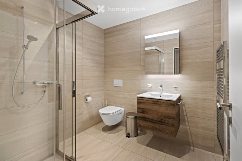 Bathroom with wooden floor, shower, toilet, sink, wooden cabinet, towel warmer, and mirror