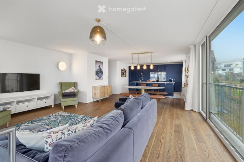 living room, couch, table, kitchen, balcony with railings, sliding glass door, television, hardwood floor, ceiling light, wall lamp, white walls, white curtains