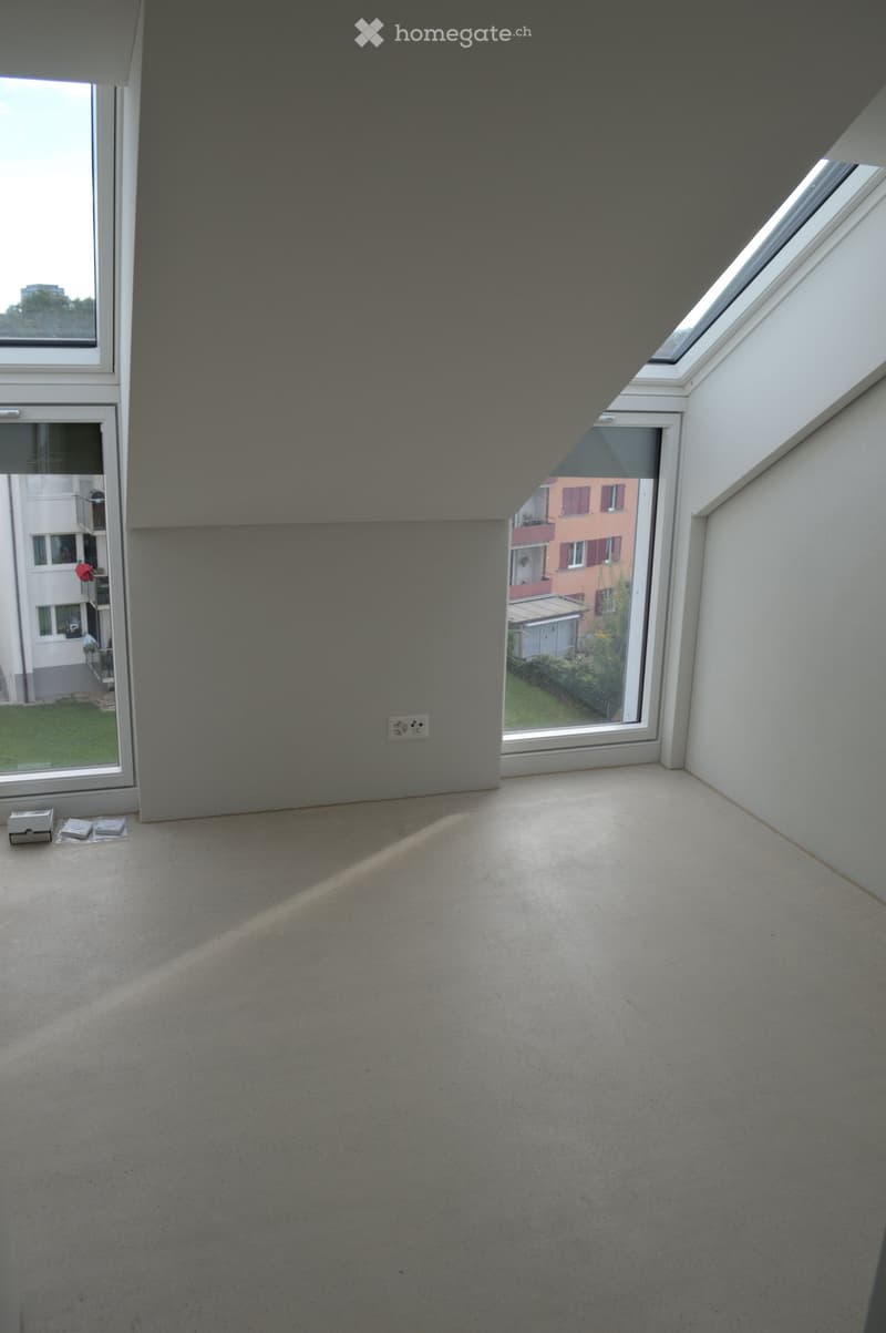 Empty room, slanted ceiling, large windows, floor outlet