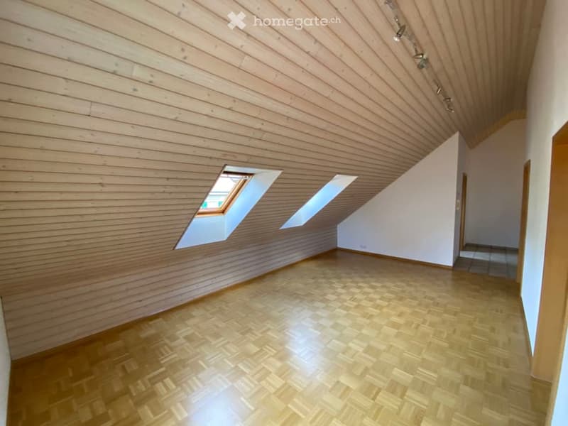 wooden walls, wooden floors, three attic windows, spotlights on the ceiling