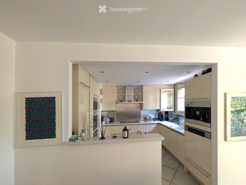 Modern and spacious kitchen with white cabinetry, white countertops, and tiled flooring. Includes a gas stove, oven, and built-in appliances such as a dishwasher and washing machine.