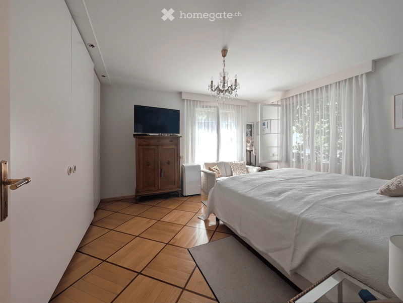 Wooden floor, bed, TV, chandelier, wardrobe, side table, armchair, decorative item