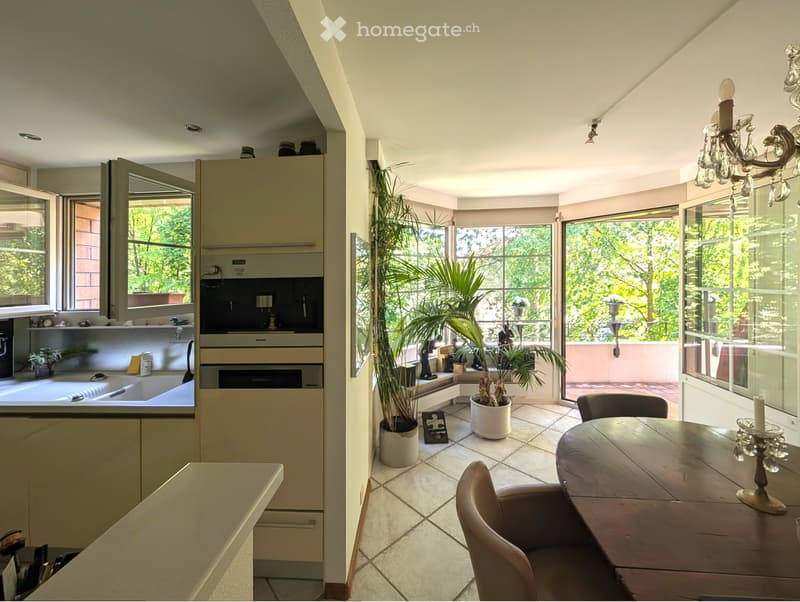 Modern kitchen, white cabinets, open window to balcony, dining table, plants, chandelier