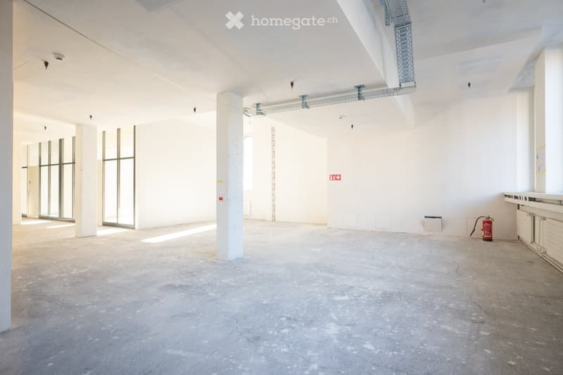 Empty room, concrete floor, glass windows, fire extinguisher.