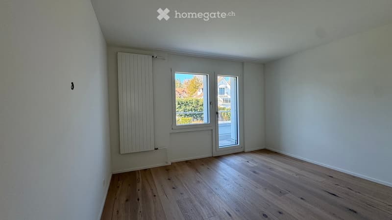 room with balcony, sliding doors, white walls, wooden floor, radiator