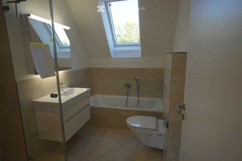 Bathroom: white bathtub, white sink, white toilet, white vanity, wooden floor, mirror, skylights