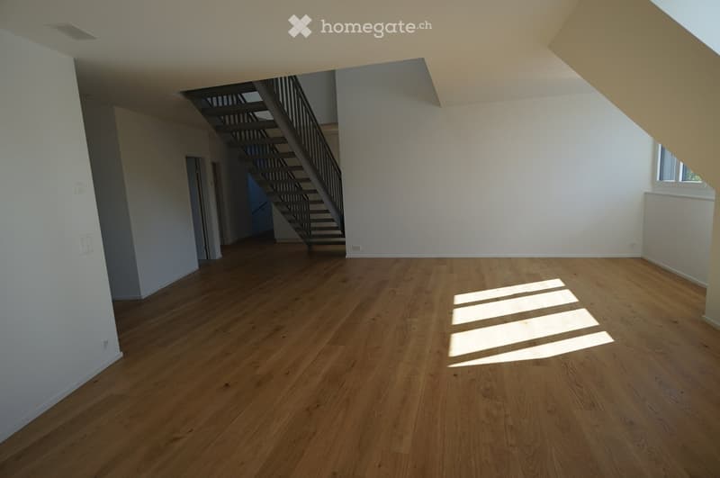 wooden floor, white walls, staircase, ceiling with beams, windows, sunlight on the floor