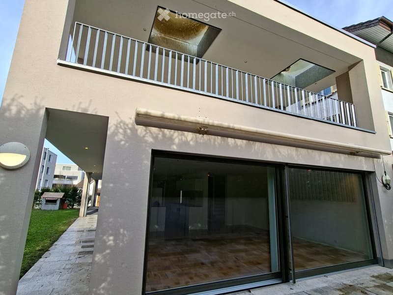 Modern house, large glass entrance doors, open balcony with railings, tiled floors, outdoor lighting