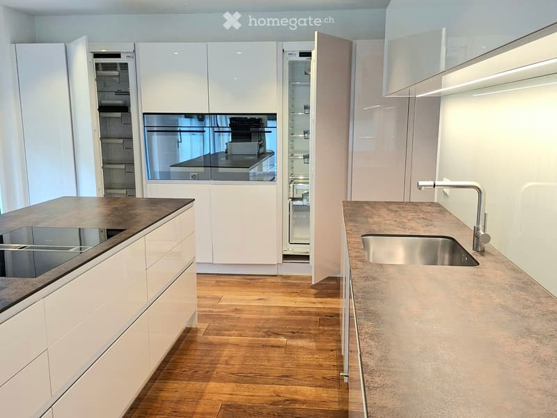 modern kitchen with wooden floor, white cabinets, open refrigerator, stove, sink, kitchen island