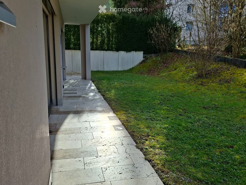 Stone entrance, small garden, lawn, white fence, bushes, grass