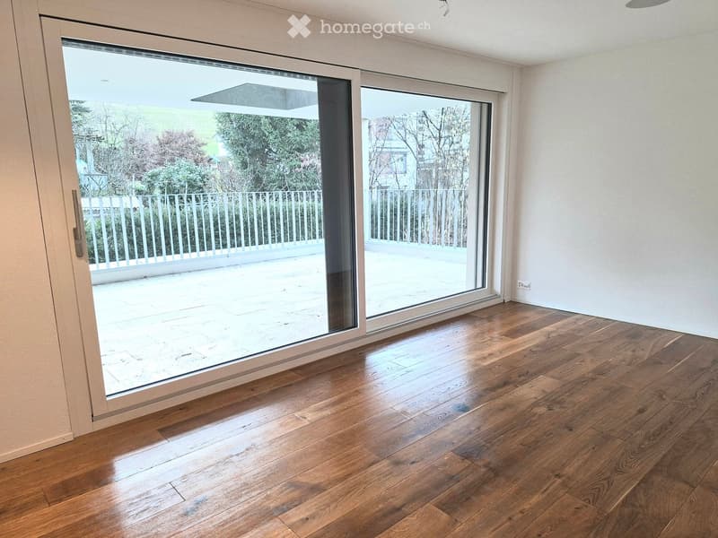 room with hardwood floor, large sliding glass doors, balcony, white walls, no visible furniture