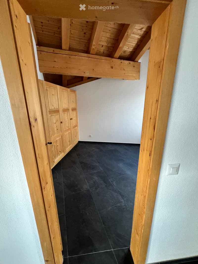 Empty room with wooden ceiling, wooden floor, wooden wardrobe, white walls
