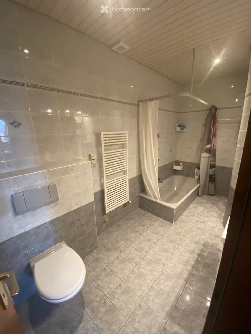 Bathroom with toilet, bathtub, and towel rack