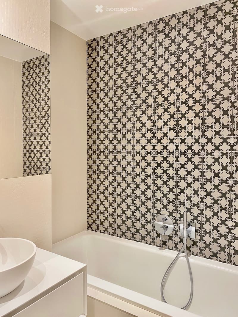 Bathroom with white bathtub, white sink, white tiles, mirror, shower head