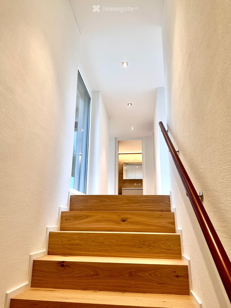 wooden staircase, white walls, wooden handrail, recessed lighting