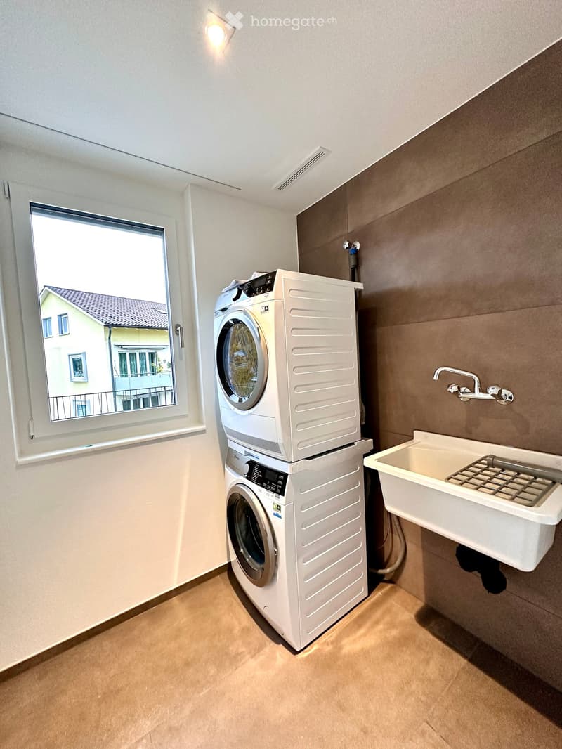 Laundry room with washing machine, dryer, sink, and window