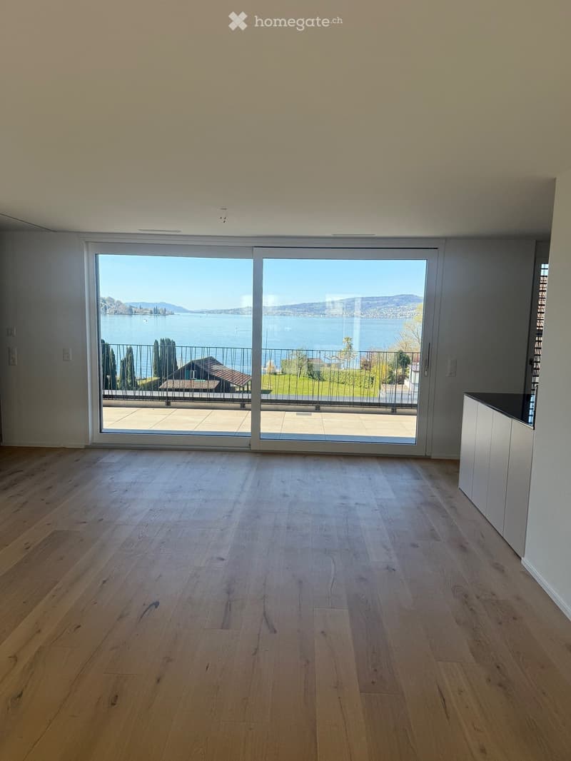 large windows, wooden floor, balcony with railing, white walls, empty room