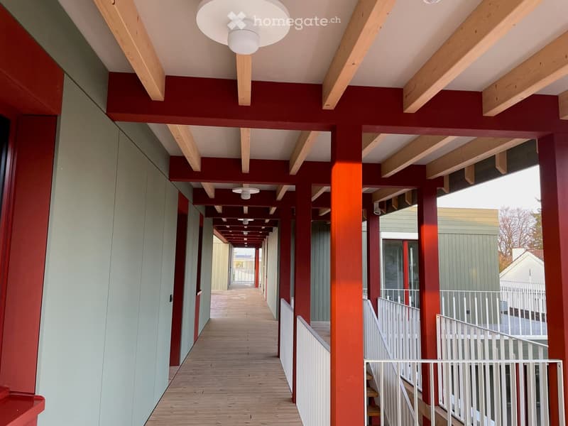 Raised ground floor with wooden columns, balcony, hallway, closed rooms, stairs