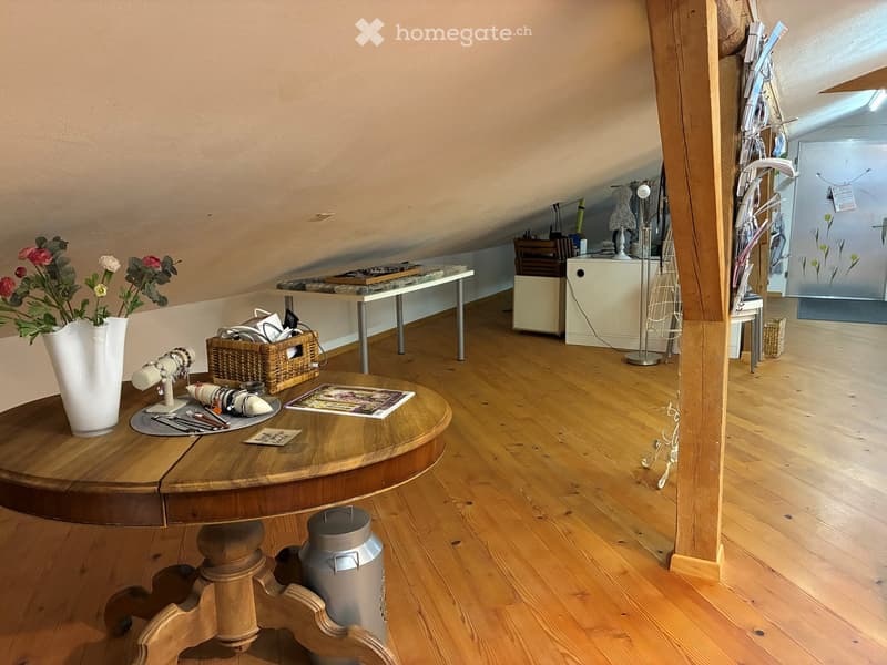 Wooden floor, white wall, table with vase and flowers, basket, small table, storage cabinet, decorative item, lamp
