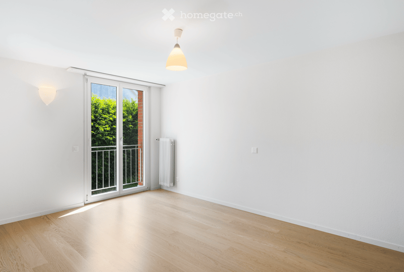 empty room, large window, sliding door to balcony, white walls, wooden floor, white radiator