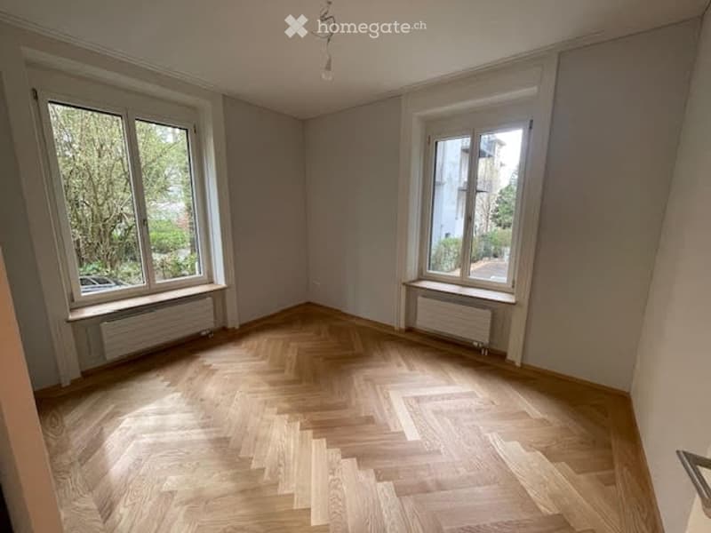 empty room, wooden floor, white walls, two large windows, radiators