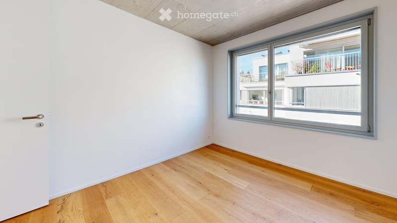 Empty room with sliding door, large window, wooden floor, white walls
