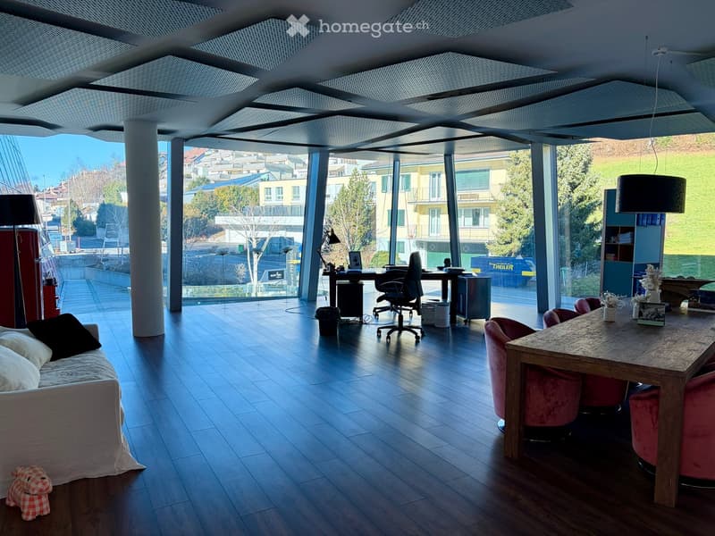 modern living room with wooden floor, office setup with desk, chairs, lamp, couch, and dining area with a wooden table and red chairs, large windows with views