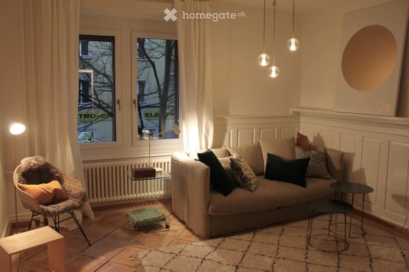 living room with a couch, windows with white curtains, radiators, and a lamp