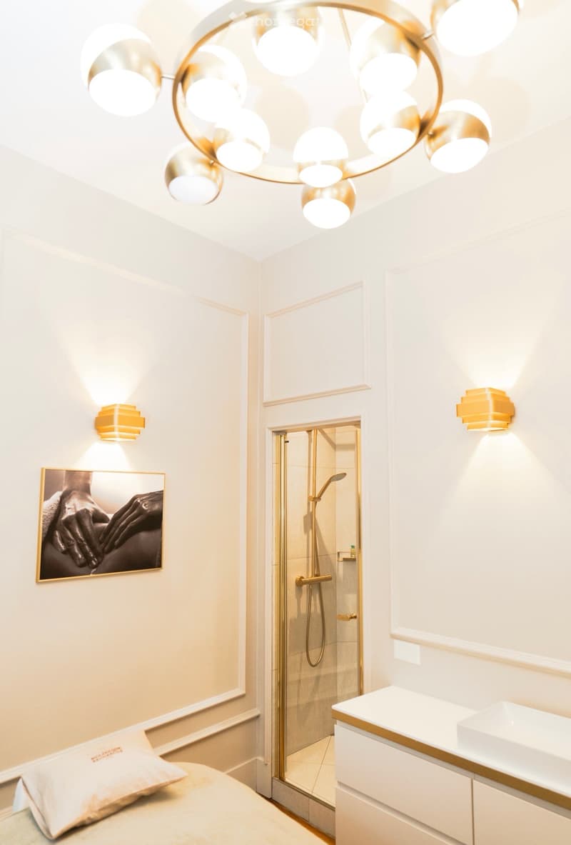 minimalistic bedroom with shower room, modern golden lighting, white walls, modern sink, golden shower room