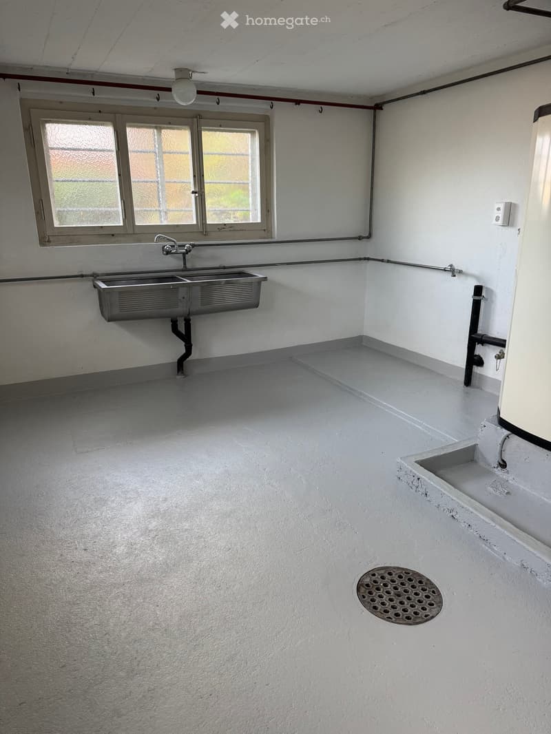 A room with double stainless steel sink, a window, and drainage