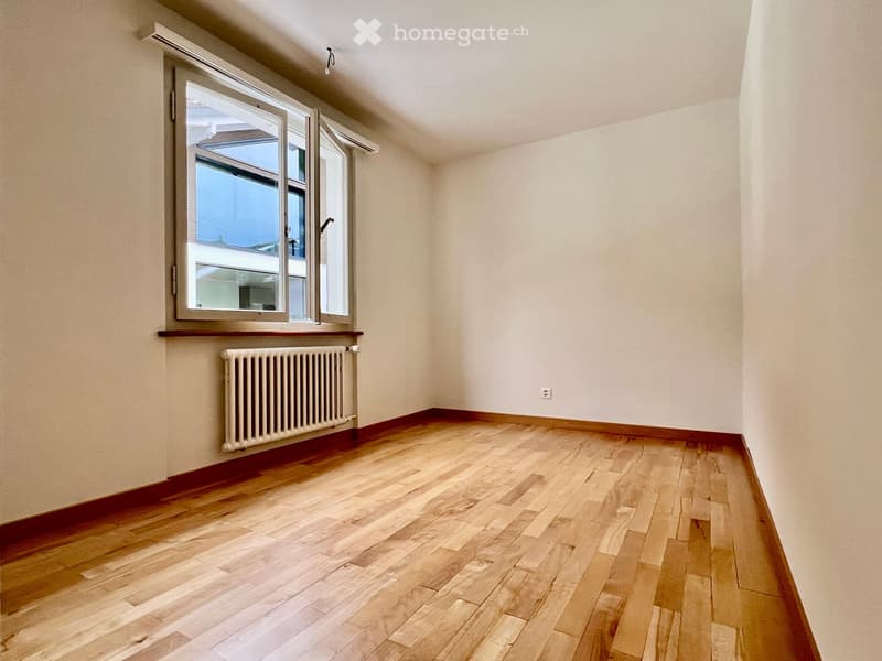 empty room, wooden floor, white walls, large window, white radiator