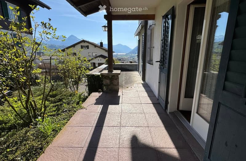 terraced front porch with stone floor, door with window, wooden awning