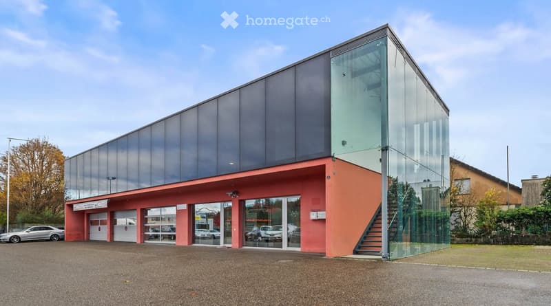 modern glass building, 2 large garage doors, stairs, parking lot