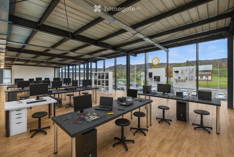 interior of a classroom with many desks, computers, monitors, storage units, lamps, tables, stools, cabinets, wall decorations, and a clock