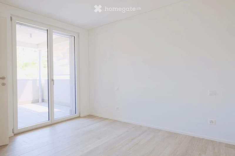 white walls, wooden floor, large sliding glass door, electrical outlets